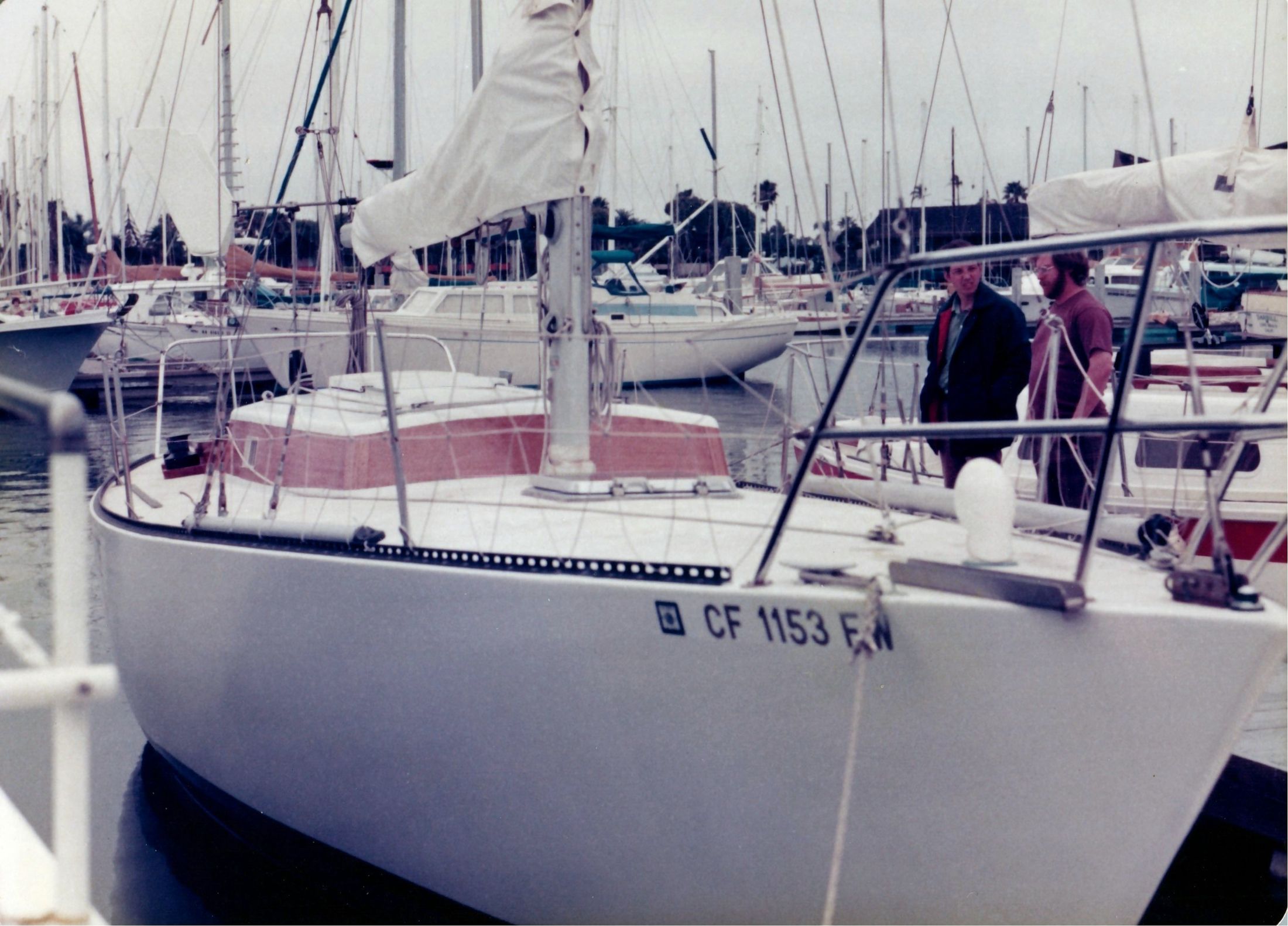 The same Peterson 33 from the dock, two men looking on from the foredeck