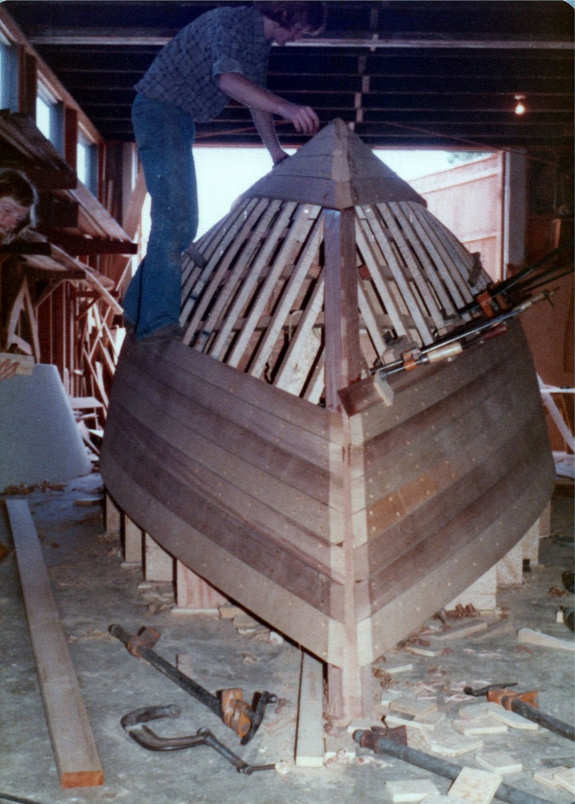 The planked bow from ahead, a man working on top