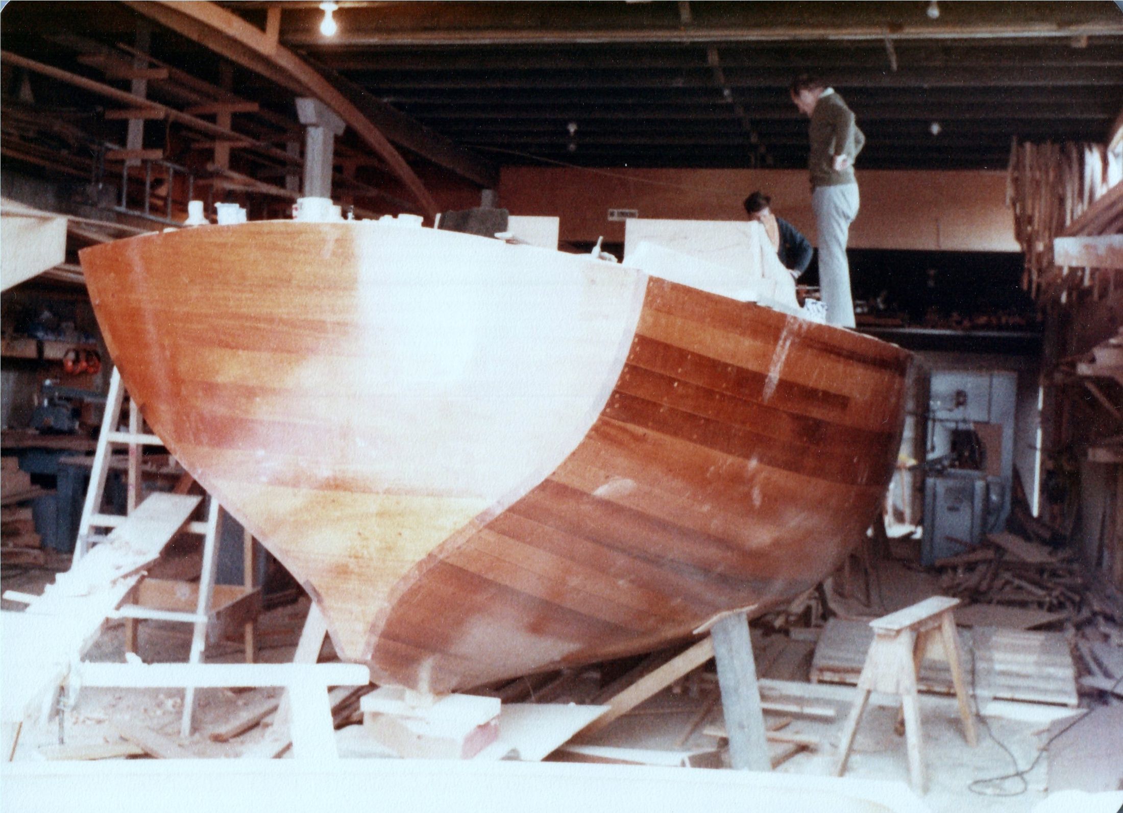 The hull with its deck on, seen from the bow, a man on the coach roof