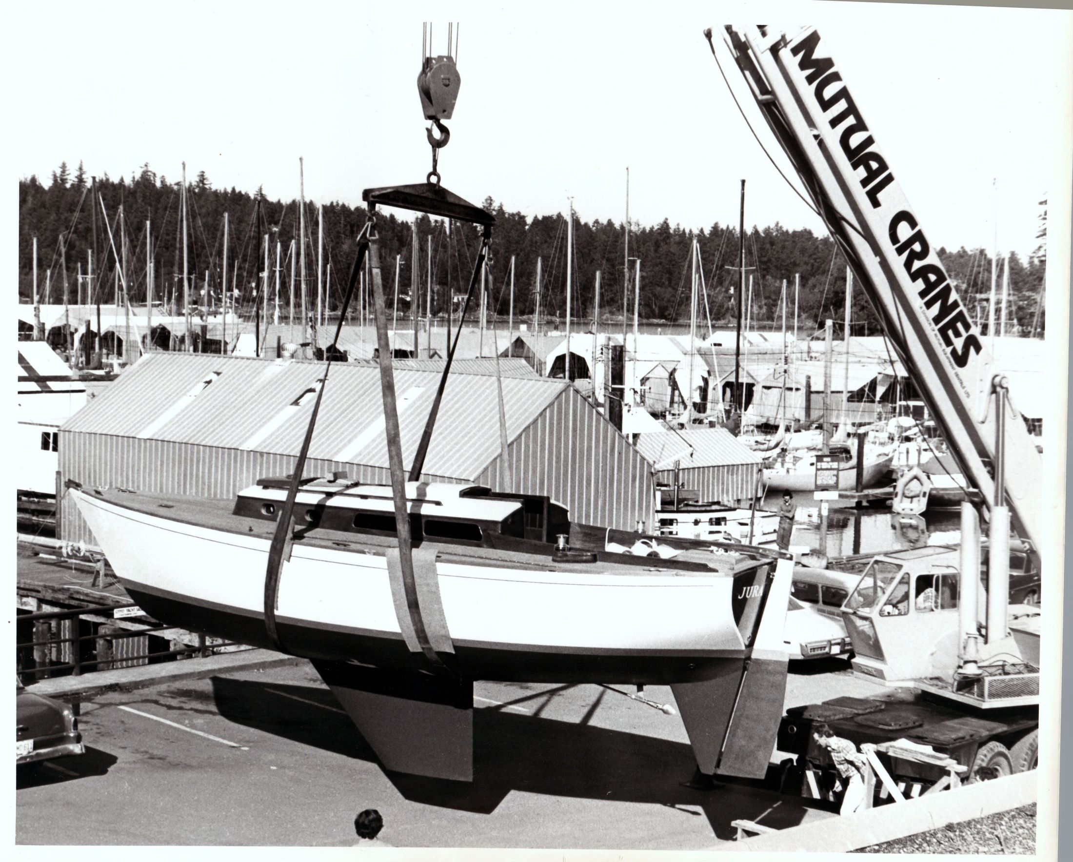 Black and white: the hull swinging from the Mutual Cranes boom over the marina