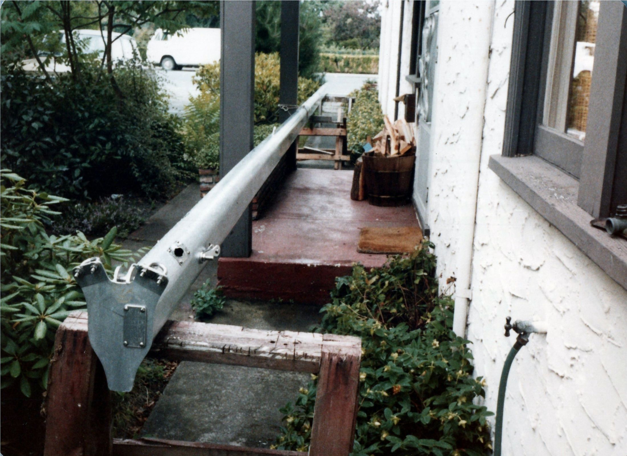 The mast lying beside a house, the foot at the camera
