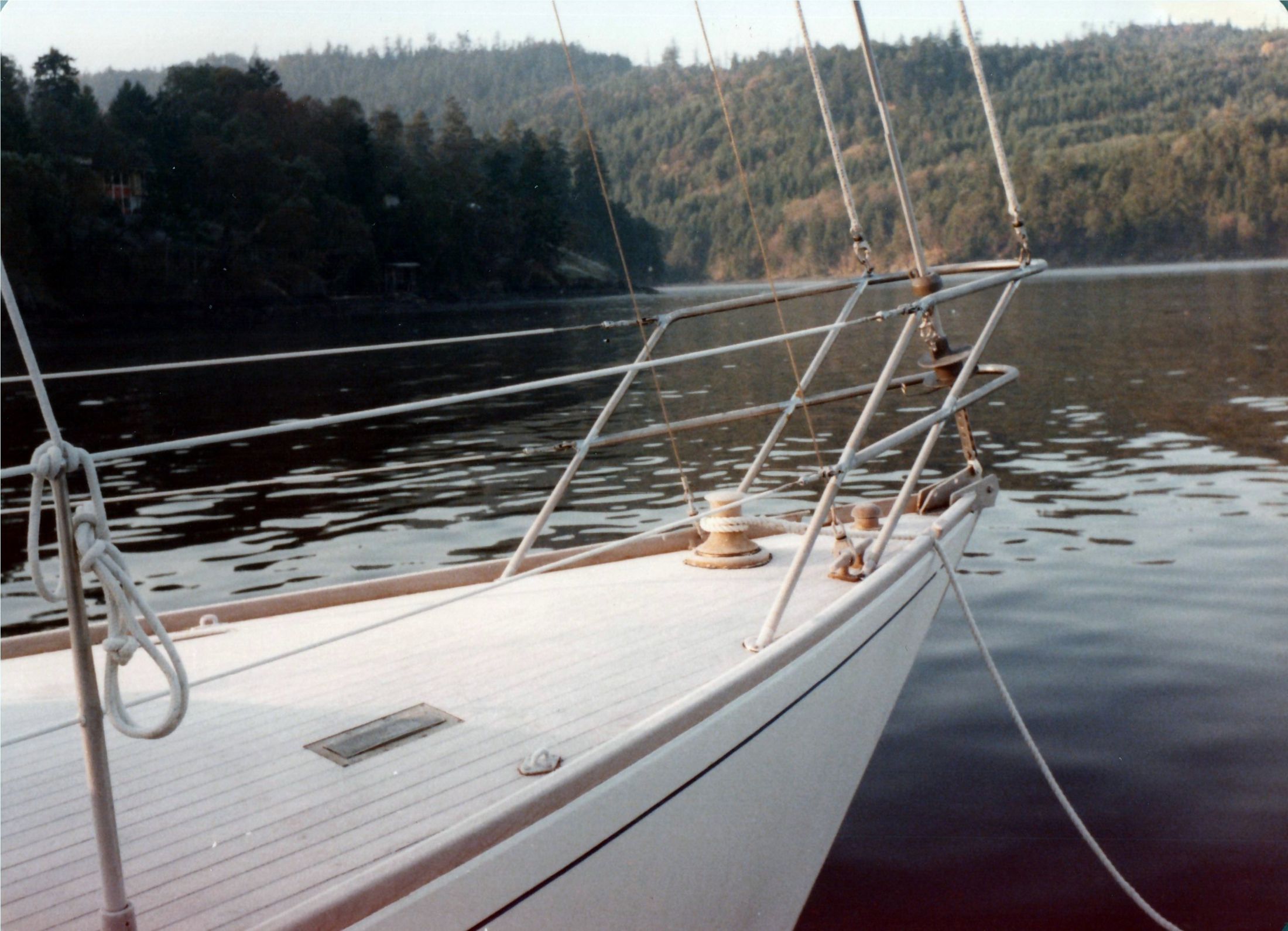 The bow and pulpit at anchor in a still cove